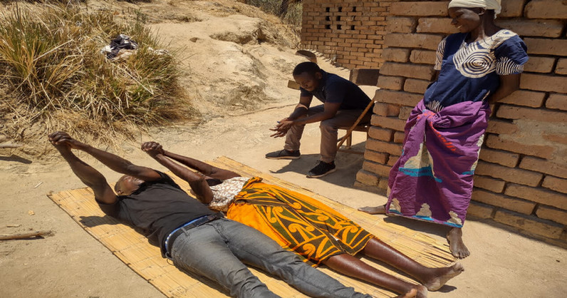 man and woman on a mat exercising